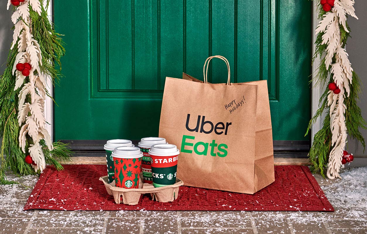 An Uber Eats delivery bag and Starbucks holiday beverages have been delivered to a wintery doorstep.