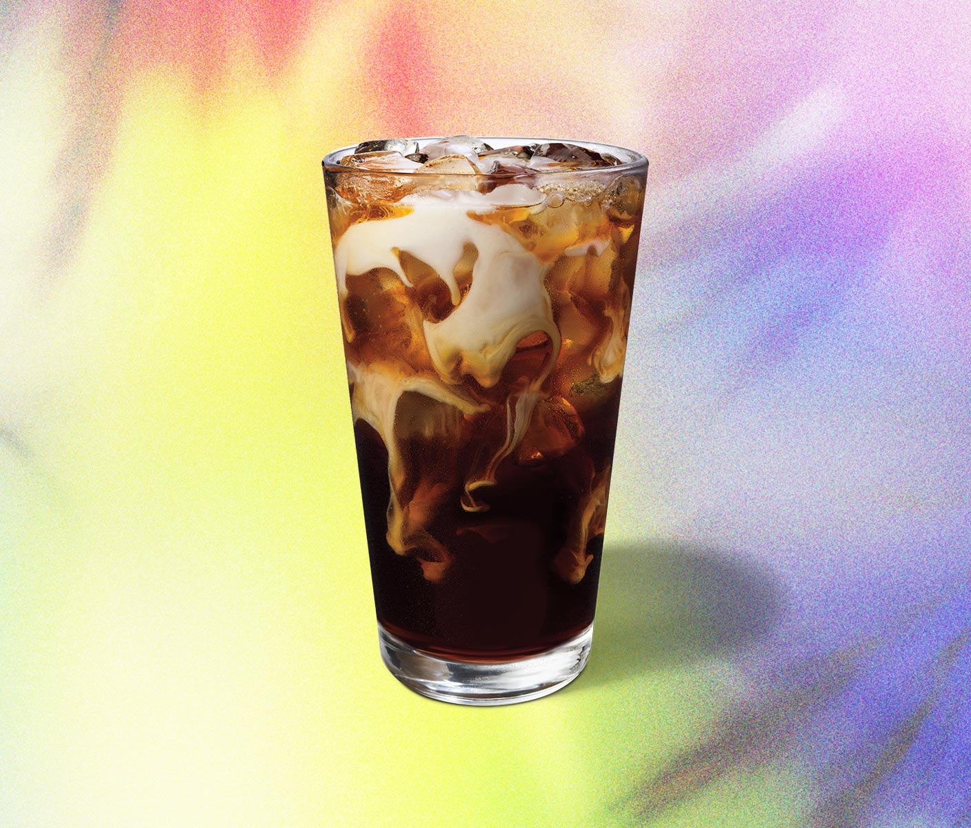 Swirls of iced coffee and cream in a glass.