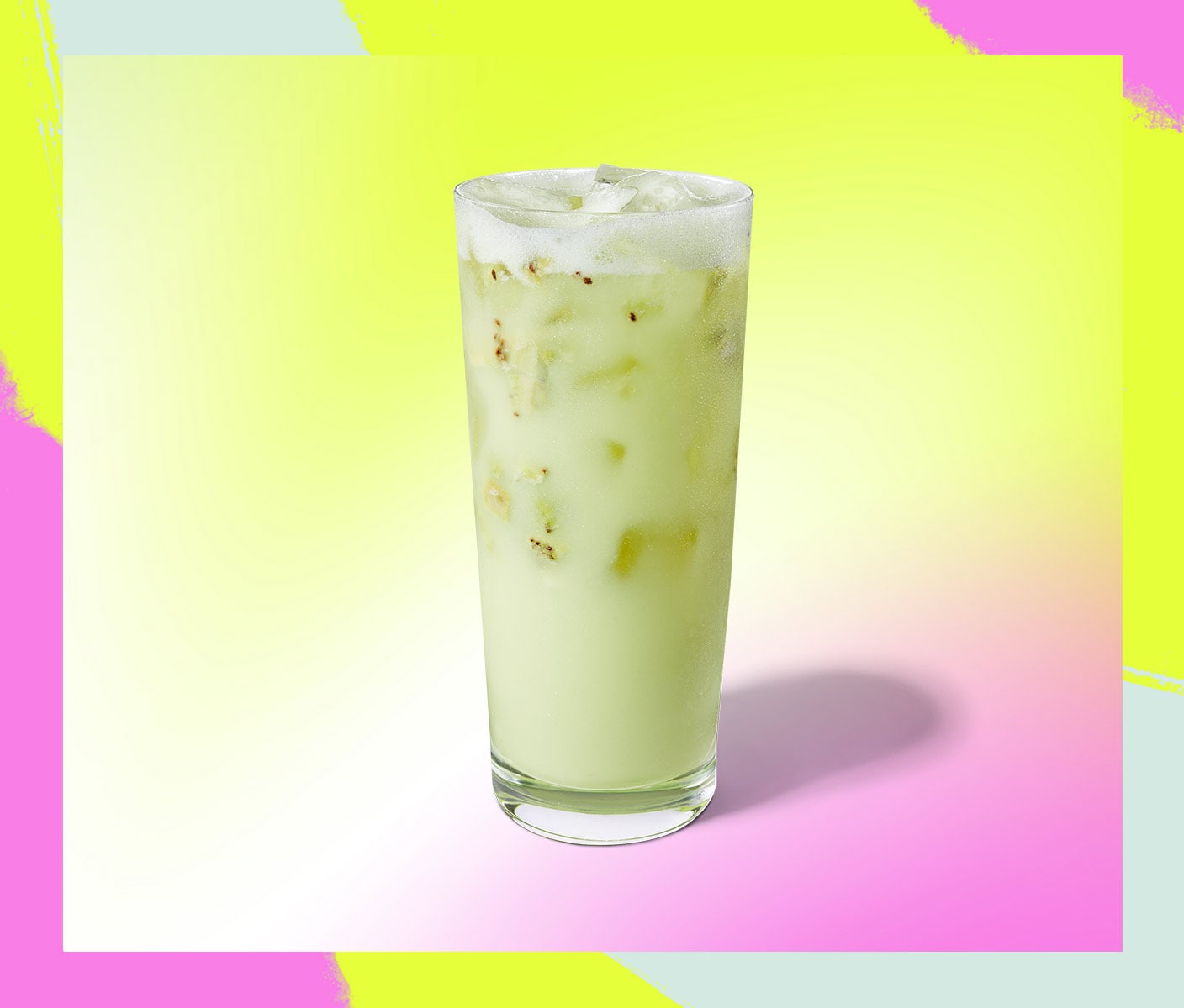 Creamy iced beverage with fruit pieces in a tall glass.