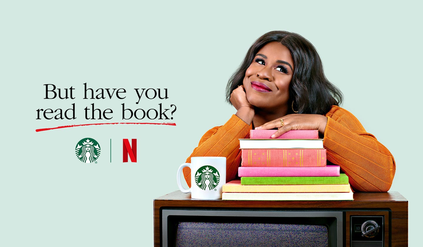 Actress Uzo Aduba poses with a pile of books, a TV and a Starbucks mug to promote a new series named But Have You Read the Book.