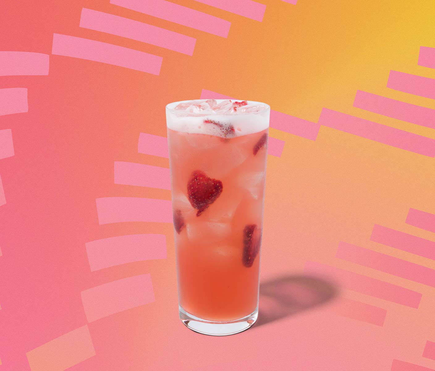 Pink iced drink with strawberry inclusions in a tall glass