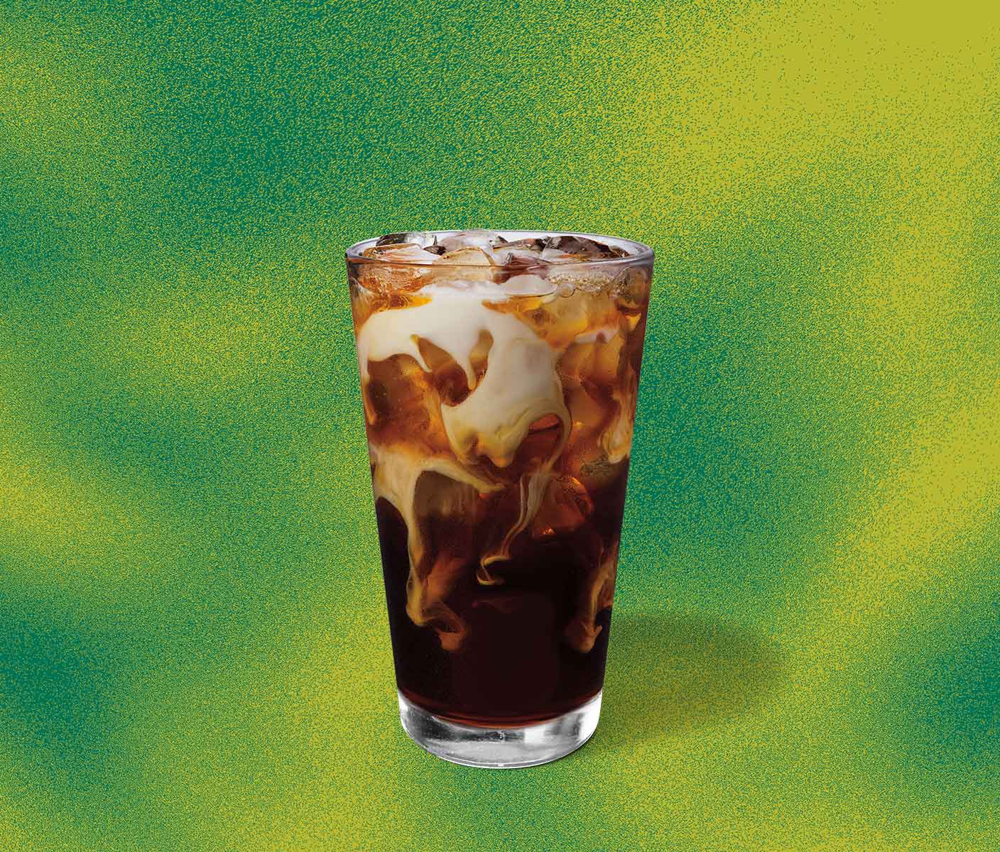 Cold coffee with creamy marbling in a tall glass.