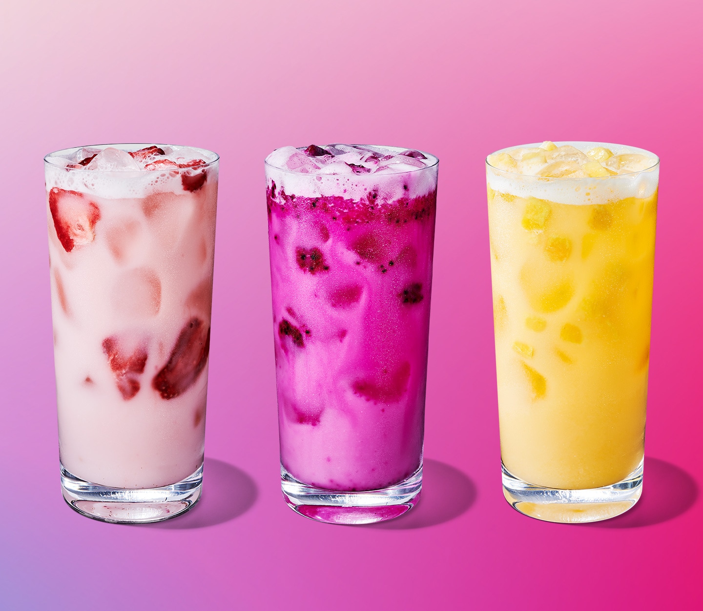 A pink drink with strawberry pieces, a darker pink drink with dragonfruit pieces, a yellow with pineapple pieces.