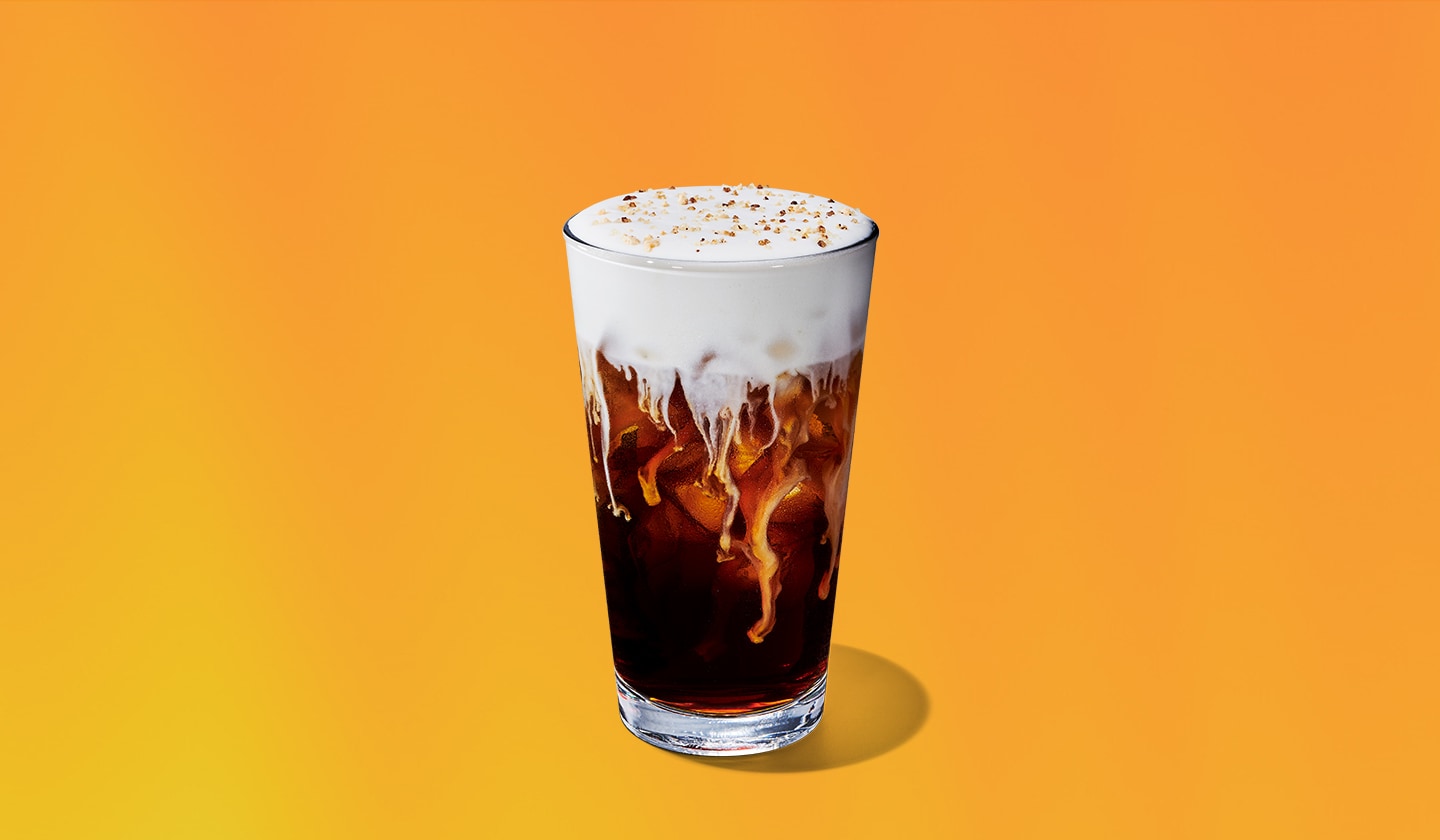 An iced coffee drink with a creamy foam topping.