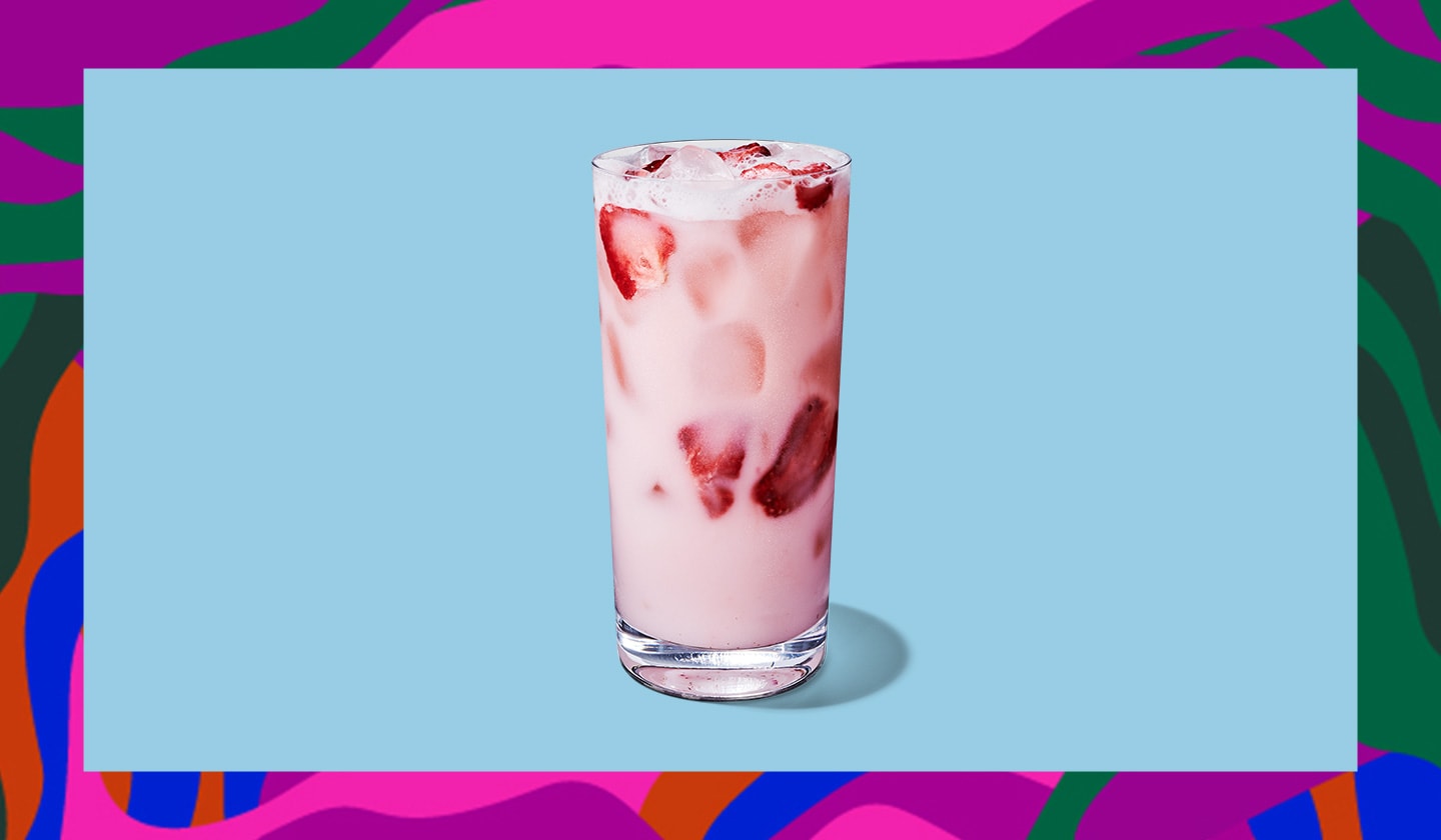 A creamy, light pink iced drink with pieces of strawberries in it.