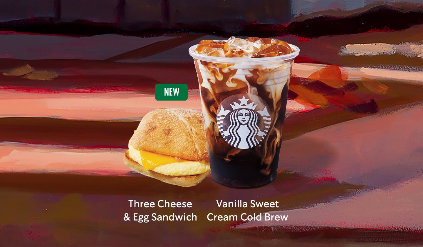 Image of a Vanilla Sweet Cream Cold Brew beside a NEW Three Cheese & Egg Sandwich