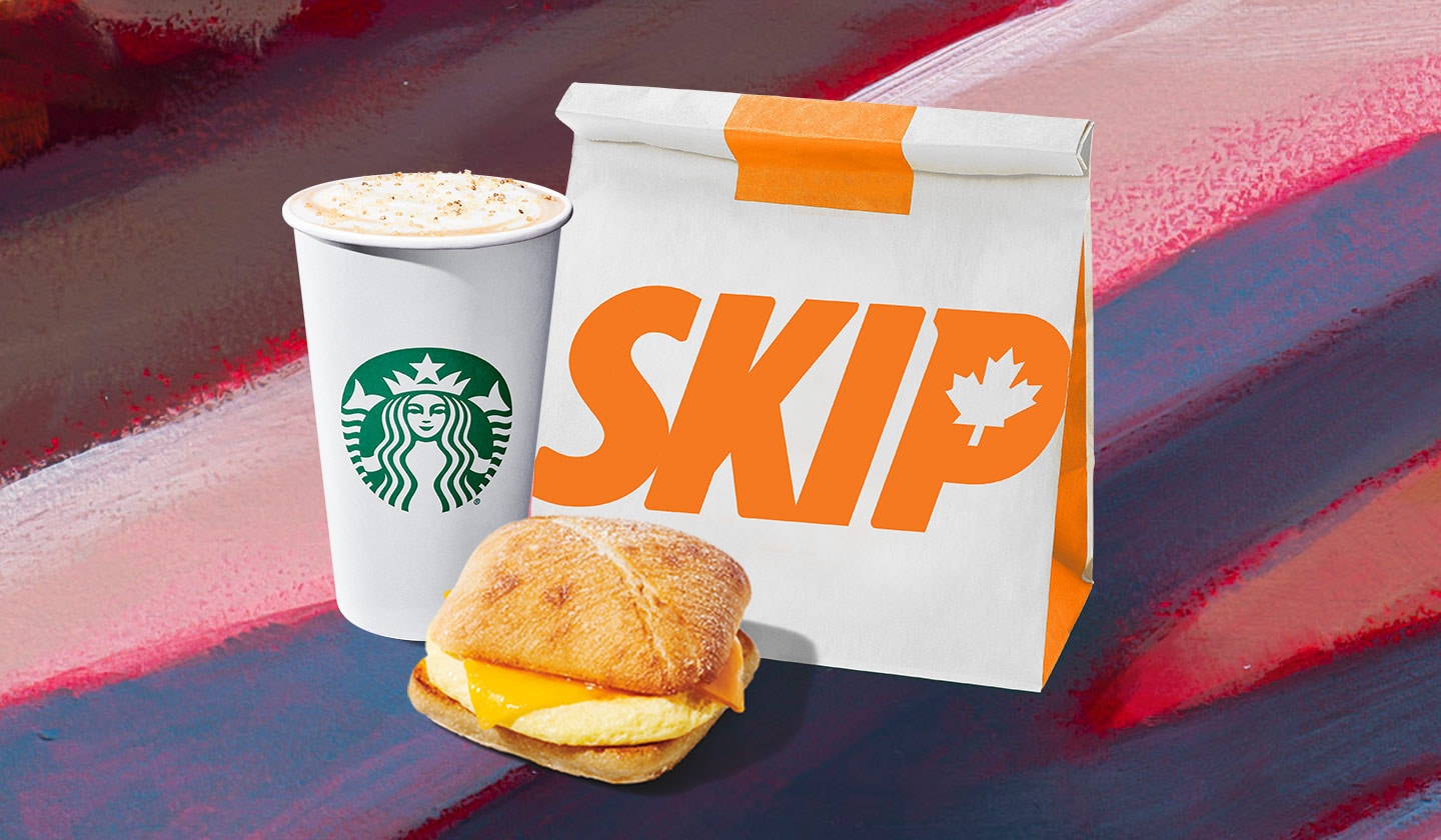 A Pumpkin Cream Chai is layered with a creamy foam and sweet, sugary flakes sprinkled on top. A Three Cheese & Egg Sandwich has perfectly melted cheese draped over the fluffy fried egg, all between toasted, floury buns. A Skip bag is packed neatly and ready for delivery.