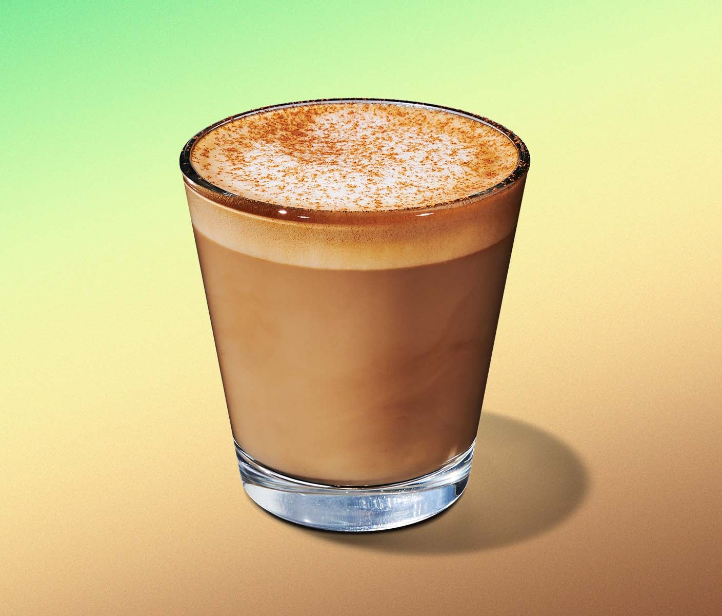 A short espresso beverage with milky crema and brown sugar topping in a glass sitting on a calming green and yellow gradient.