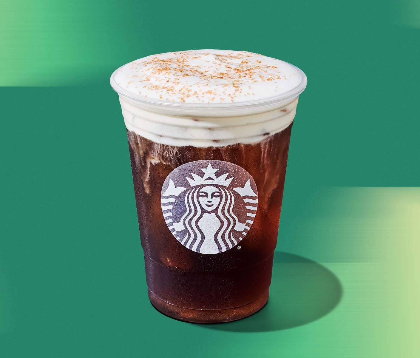 A transparent cold cup with frosted Starbucks Siren showing cold brew topped with white cold foam and a light brown butter topping.