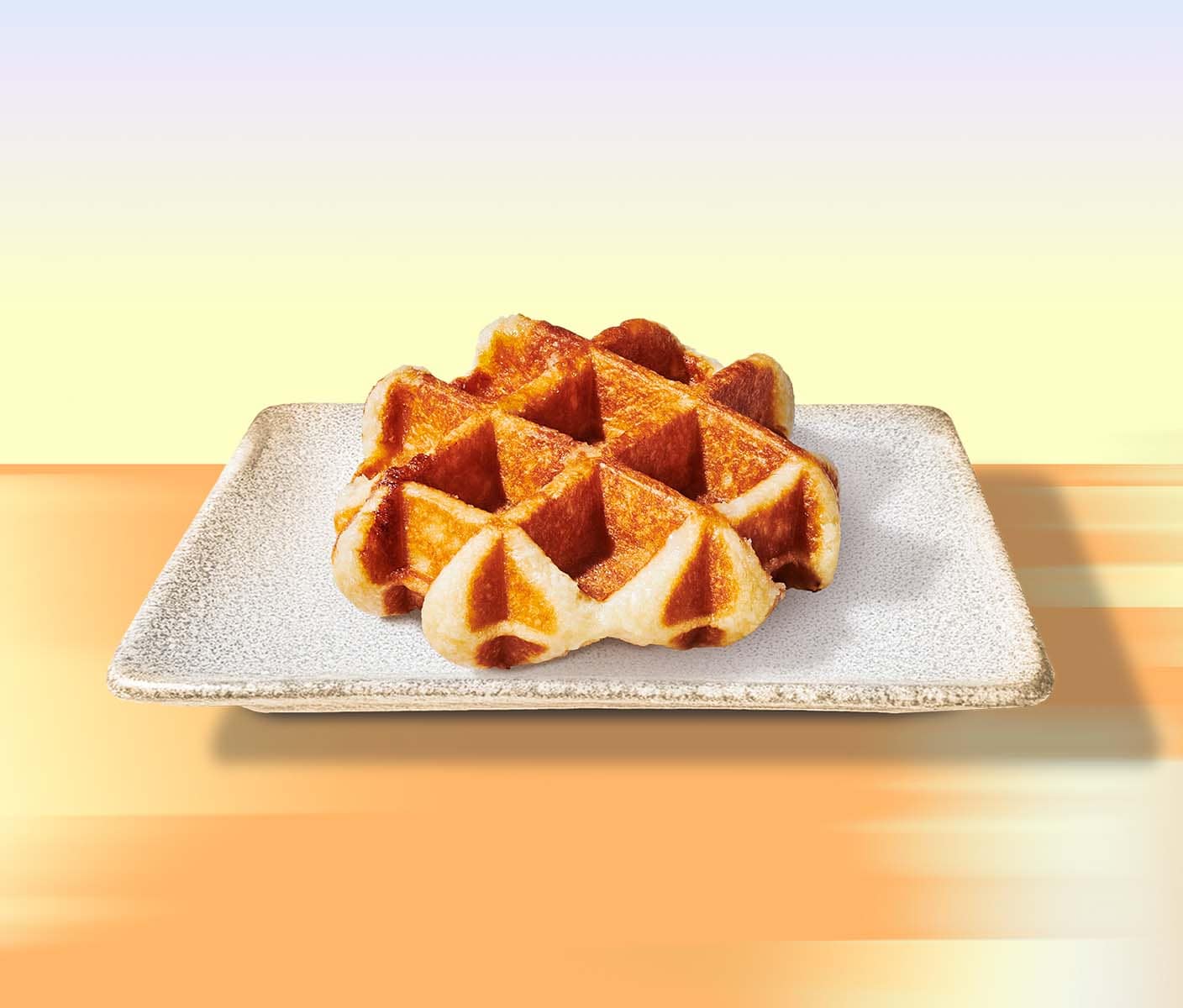 A golden brown waffle on a rectangular plate. The background gradates from orange to yellow to blue.