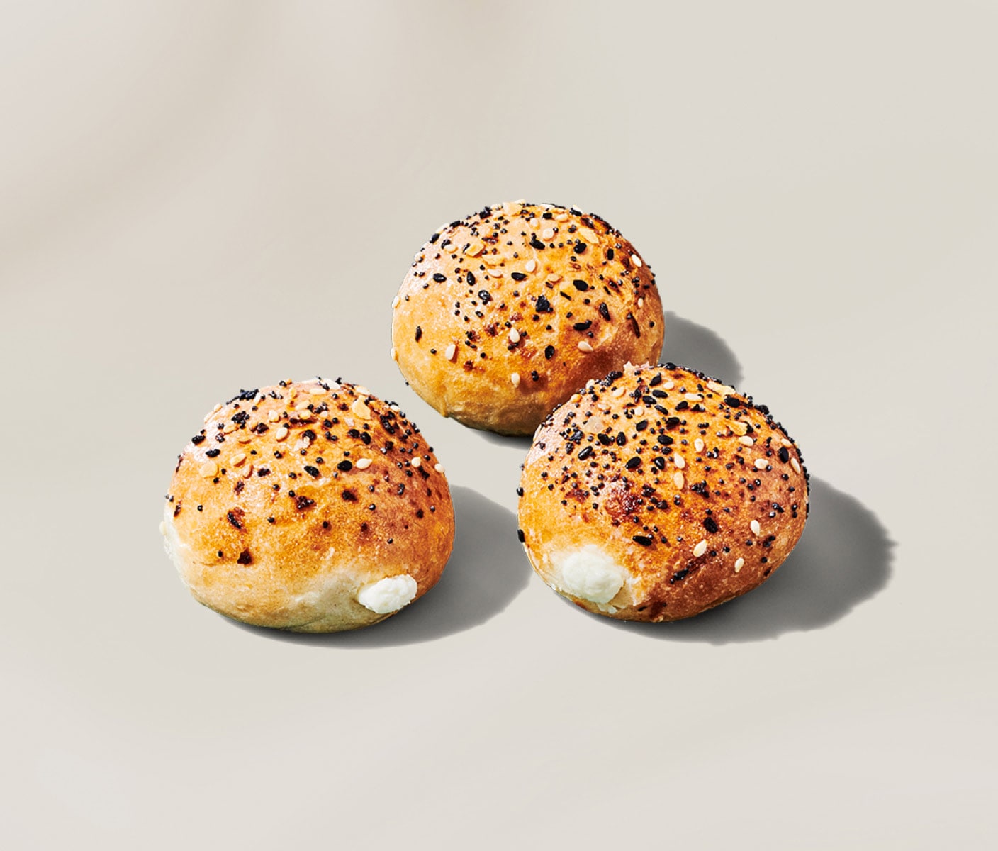 Trois minibagels garnis de fromage à la crème et recouverts d’assaisonnement plein goût, avec des graines de sésame, de l’oignon, de l’ail et des graines de pavot.