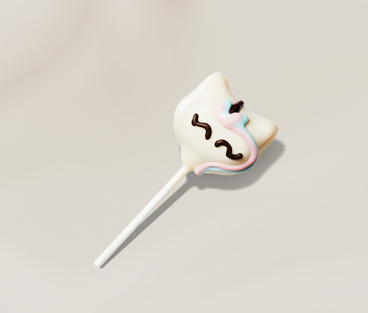 Gâteau-suçon blanc en forme de licorne avec glaçage rose, bleu et noir sur fond beige.