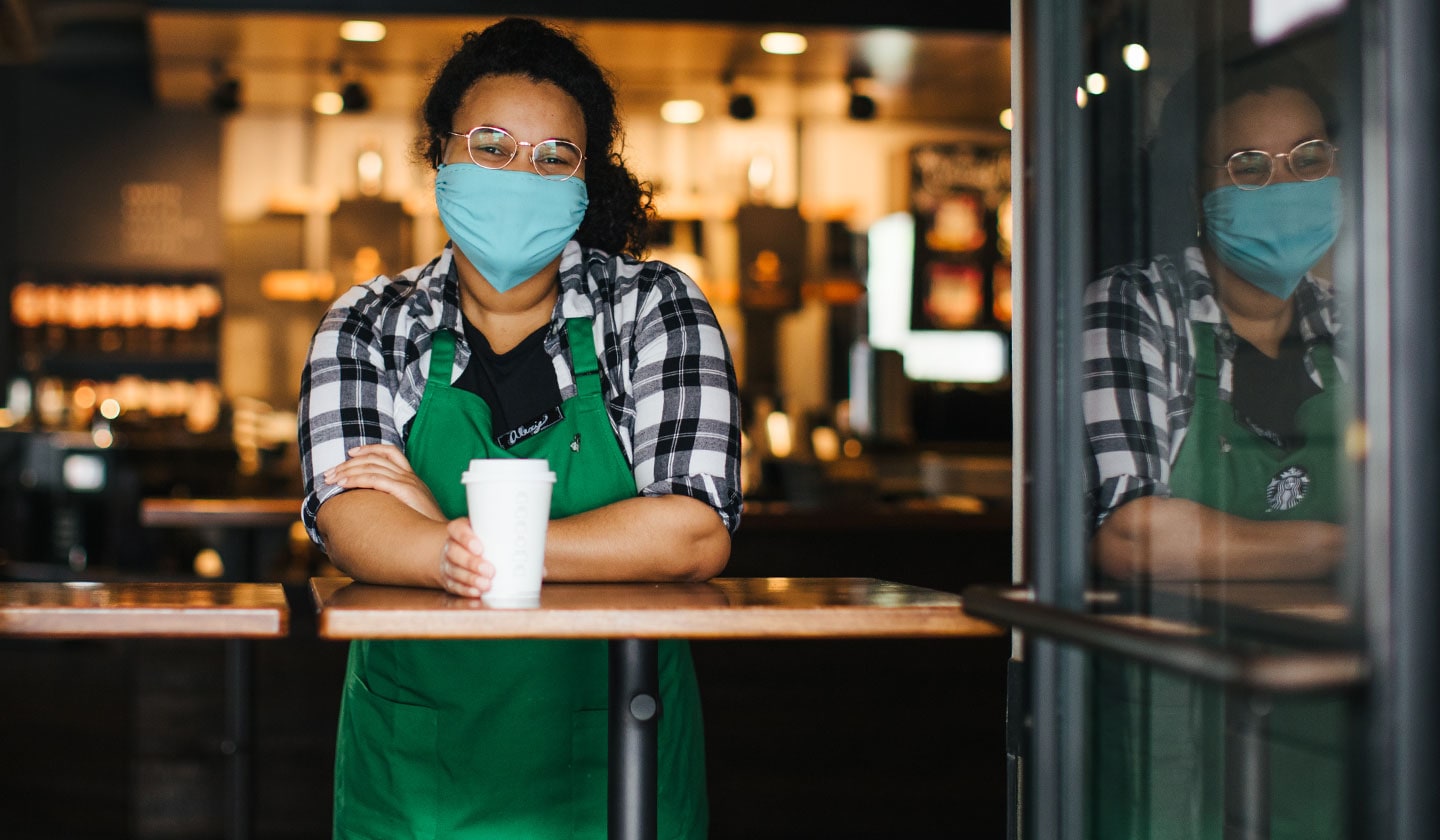 Barista Starbucks avec un couvre-visage.