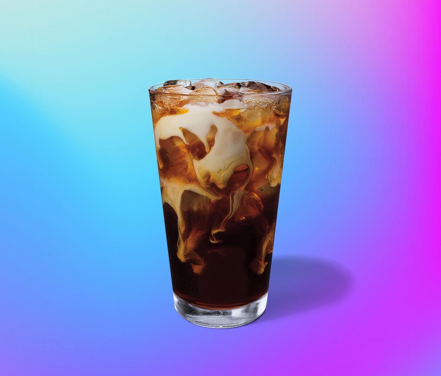 Un café glacé avec des tourbillons de crème dans un verre transparent