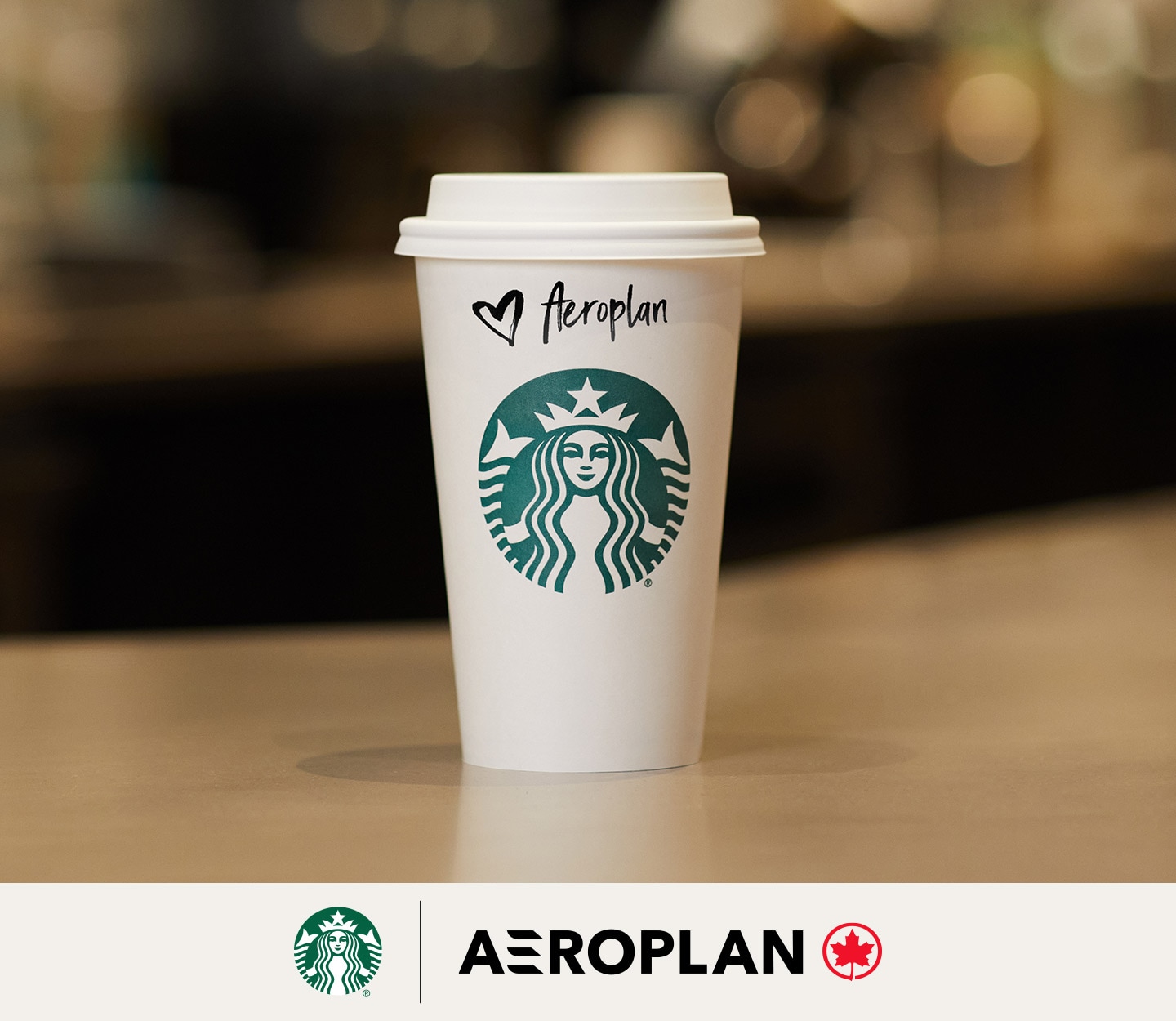 Une tasse Starbucks format Mezzo avec un couvercle posée sur le bar du café et qui attend son client. Le nom du client sur la tasse est Aéroplan.