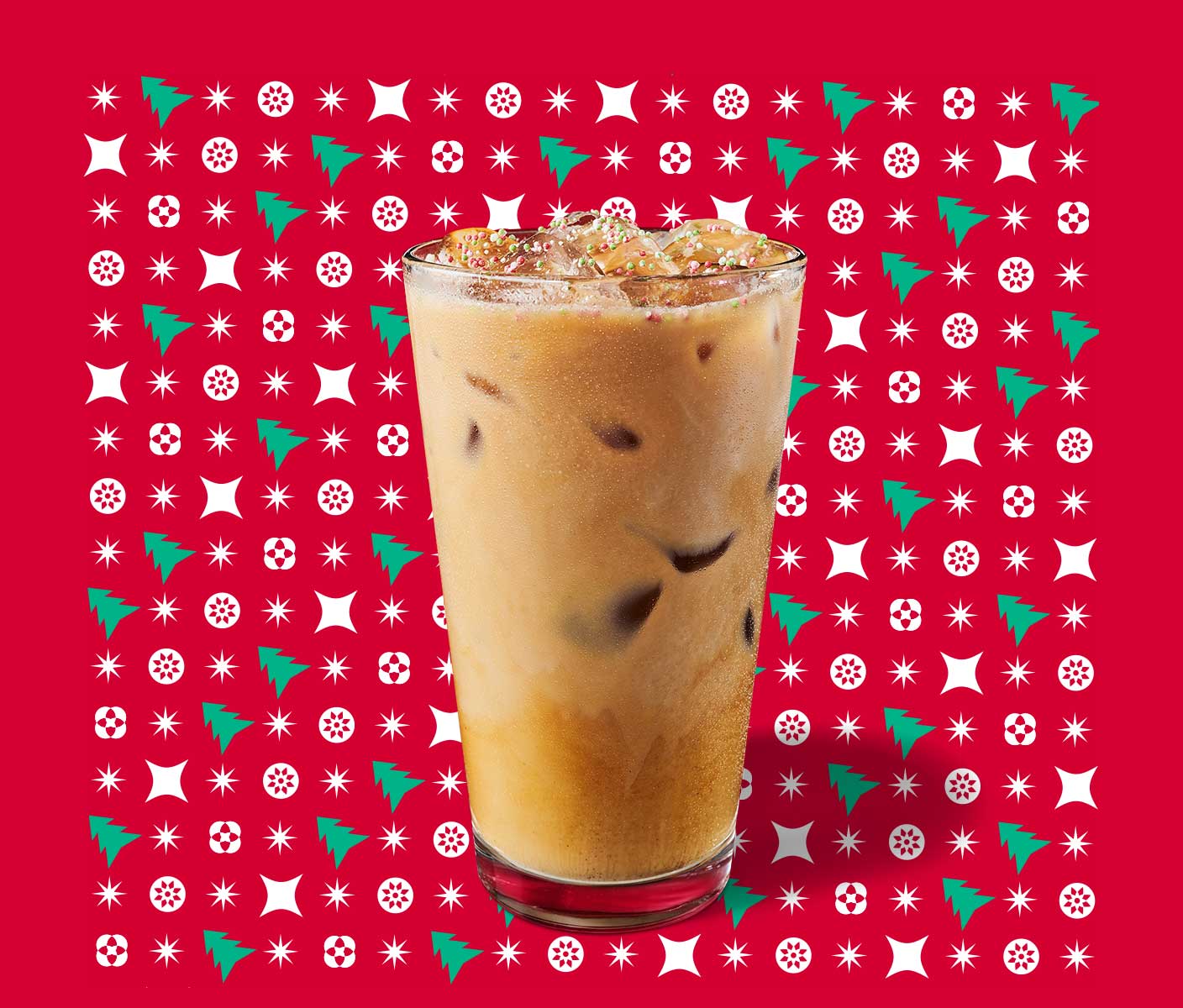 Une boisson glacée et crémeuse à base d’espresso servie dans un grand verre et garnie de paillettes rouges et vertes.