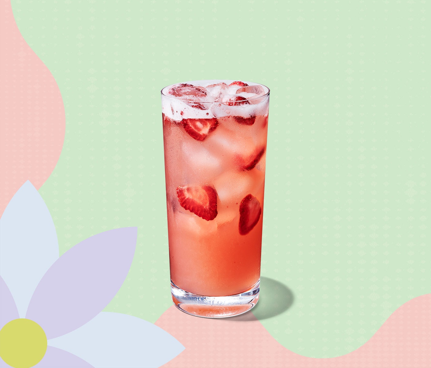Une boisson glacée de couleur rose contenant des morceaux de fraises.
