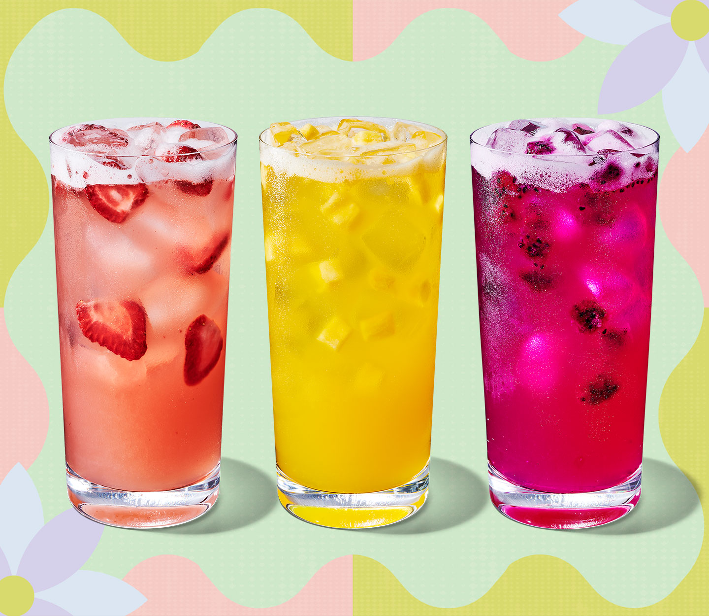 Trois boissons glacées colorées contenant des morceaux de fruits.