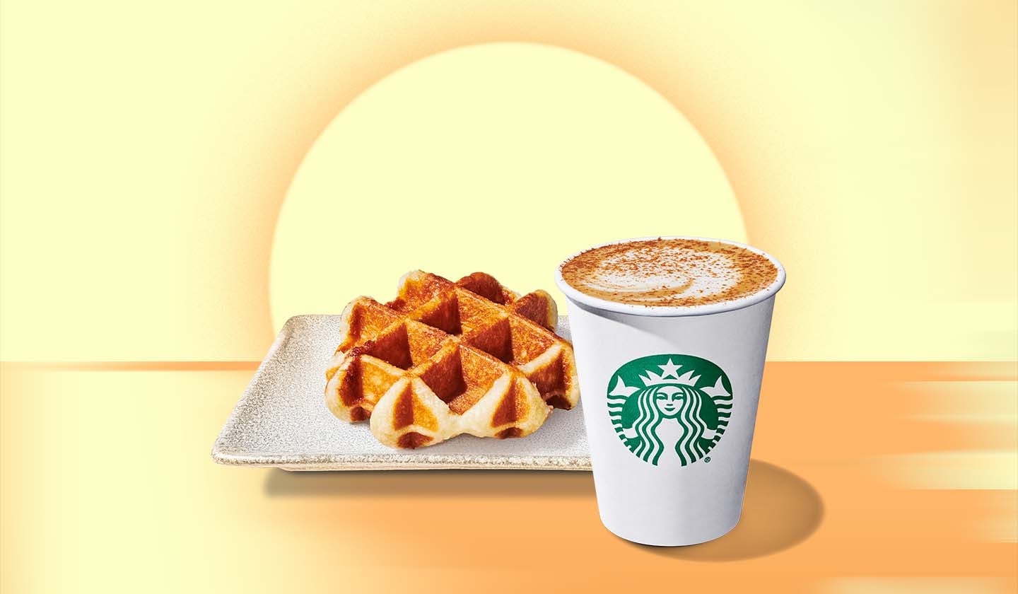 Une gaufre dorée à la perfection sur une assiette en grès accompagnée d'un gobelet blanc Starbucks rempli d'une boisson espresso, sur un fond jaune avec un soleil levant en arrière-plan.