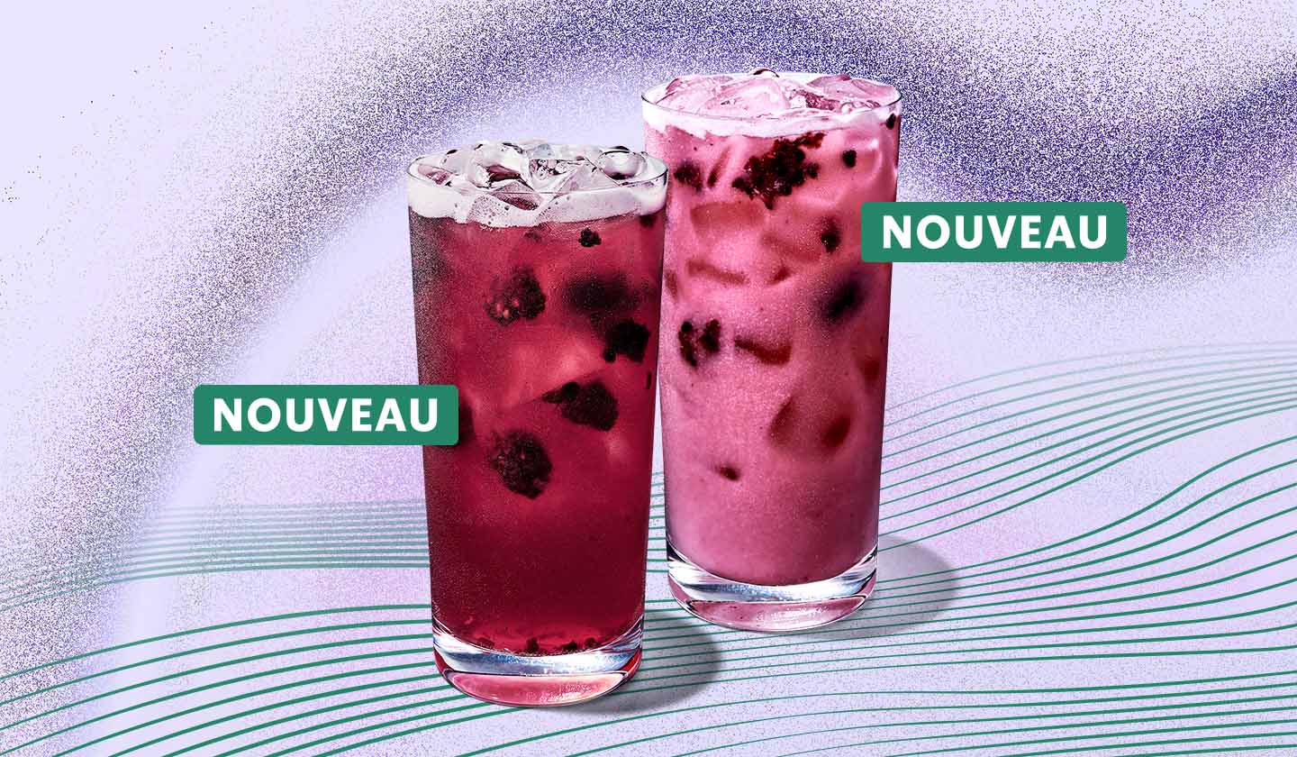 Deux boissons Starbucks Refresher dans des verres sur un fond violet pâle avec lignes vertes ondulées. L'une des boissons est d'un violet translucide où l’on voit des mûres séchées et de la glace, tandis que la seconde est d'un violet plus clair et plus opaque. Chaque boisson porte un petit autocollant vert indiquant que le produit est nouveau.