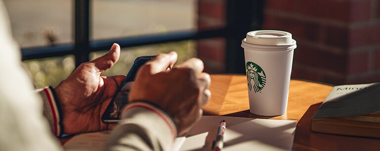 Close-up of customer holding mobile phone.